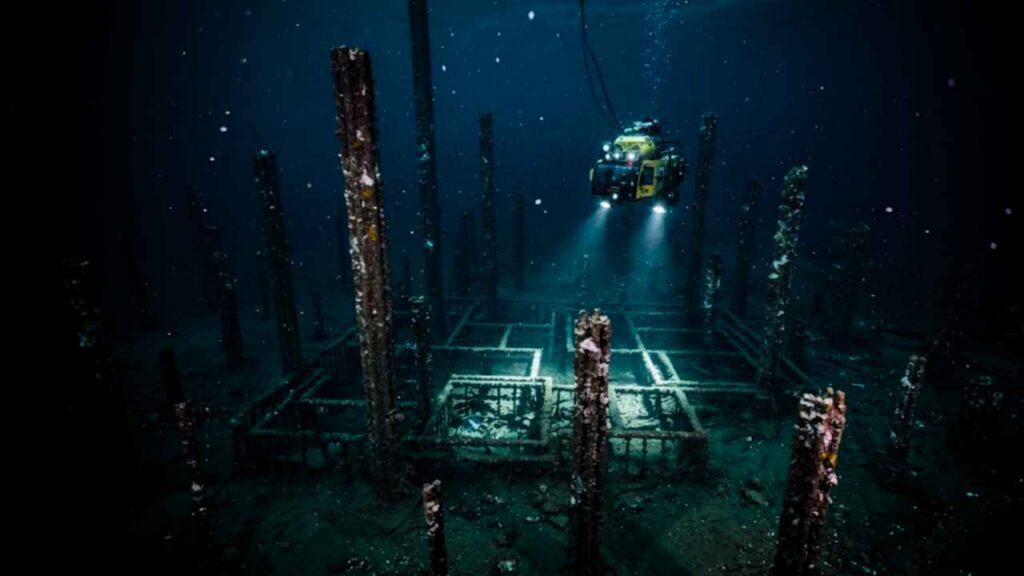Torres minerais verticais de 20 metros iluminadas por luzes do ROV KAIKO no fundo da Fossa de Izu-Bonin, zona hadal a 8 mil metros de profundidade no Oceano Pacífico.