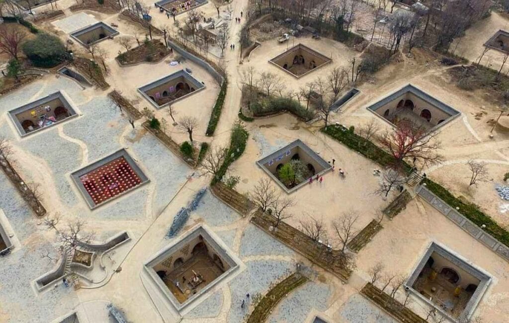 Vista aérea de pátios subterrâneos quadrados com casas caminhos árvores e pessoas caminhando china Cidades debaixo da terra