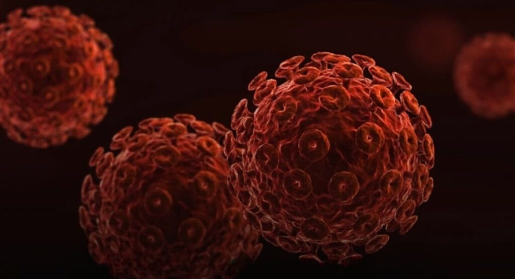 ilustração de vírus em tons de vermelho e laranja, com estrutura esférica e espinhos, contra fundo escuro, sugerindo representação de patógenos microscópicos. Casos de HIV