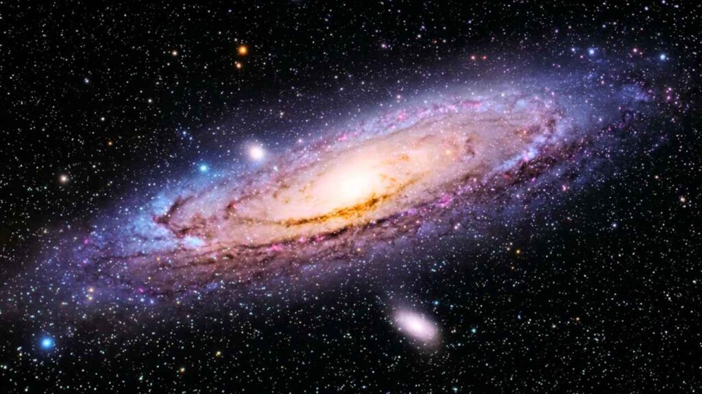Grande galáxia CEERS-2112 espiral brilhante com tons de roxo, azul e dourado, exibindo seus braços cósmicos em meio a um fundo repleto de estrelas no espaço sideral.